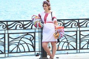 Стаття ФОТОФАКТ. В Крыму девушка в вышиванке торгует веночками на набережной Ранкове місто. Крим